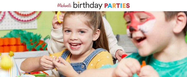 A young child at a birthday party does a craft and smiles.